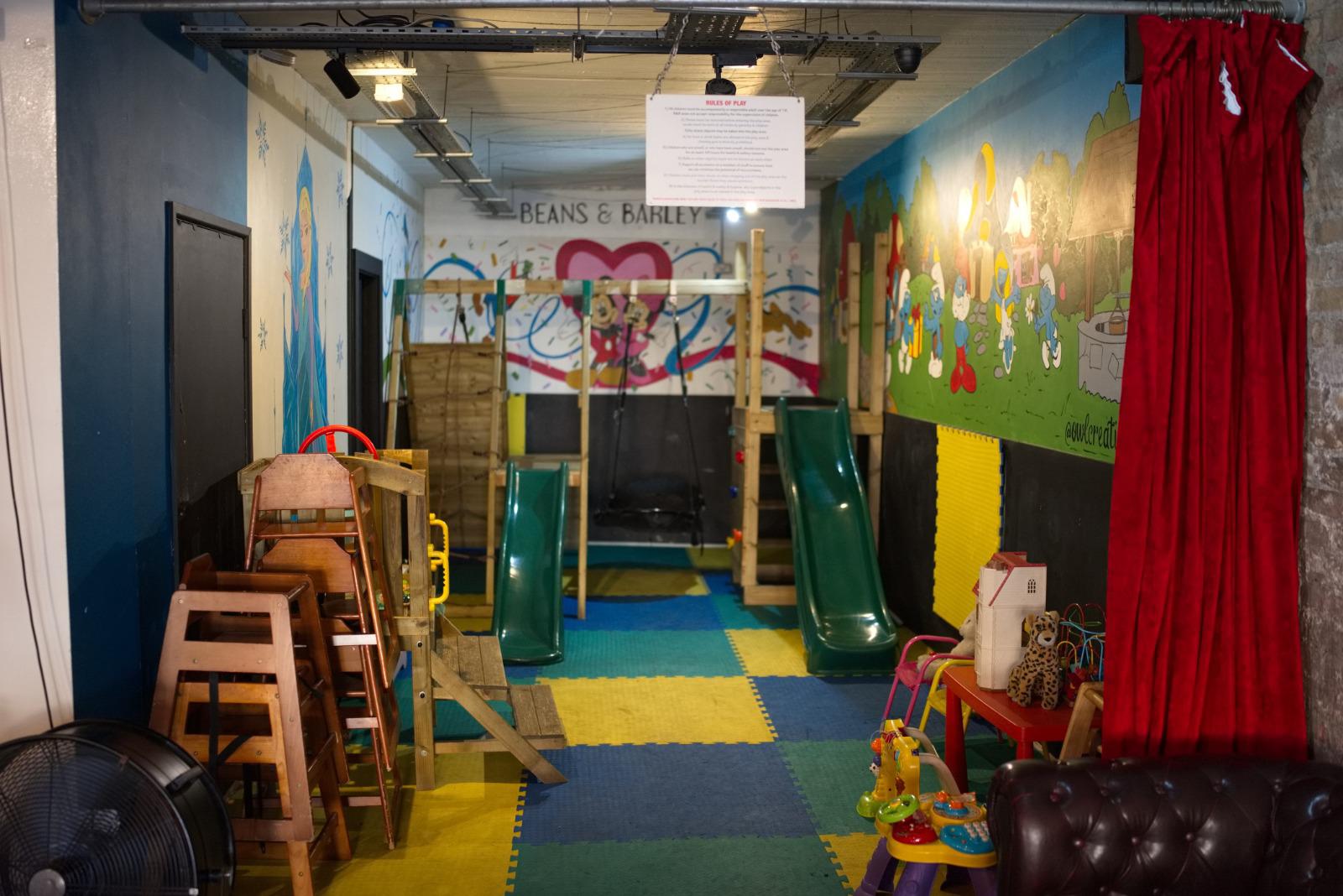 The soft-play room — slides, swing, mural and play mats